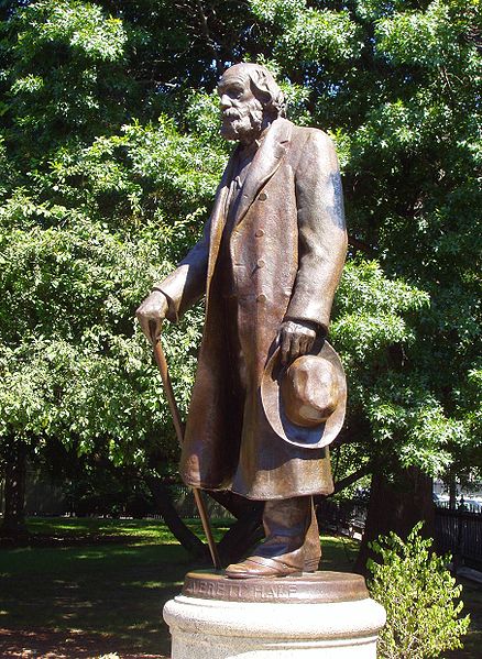 A bronze and marble statue of an elderly Edward Everett Hale stands in a green spacious garden.